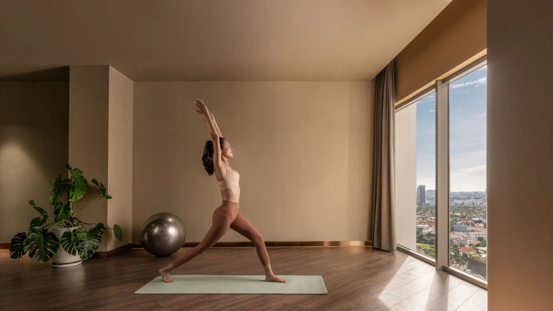 Phòng tập yoga với cửa kính lớn nhìn ra toàn cảnh thành phố tại The Berkley Thảo Điền